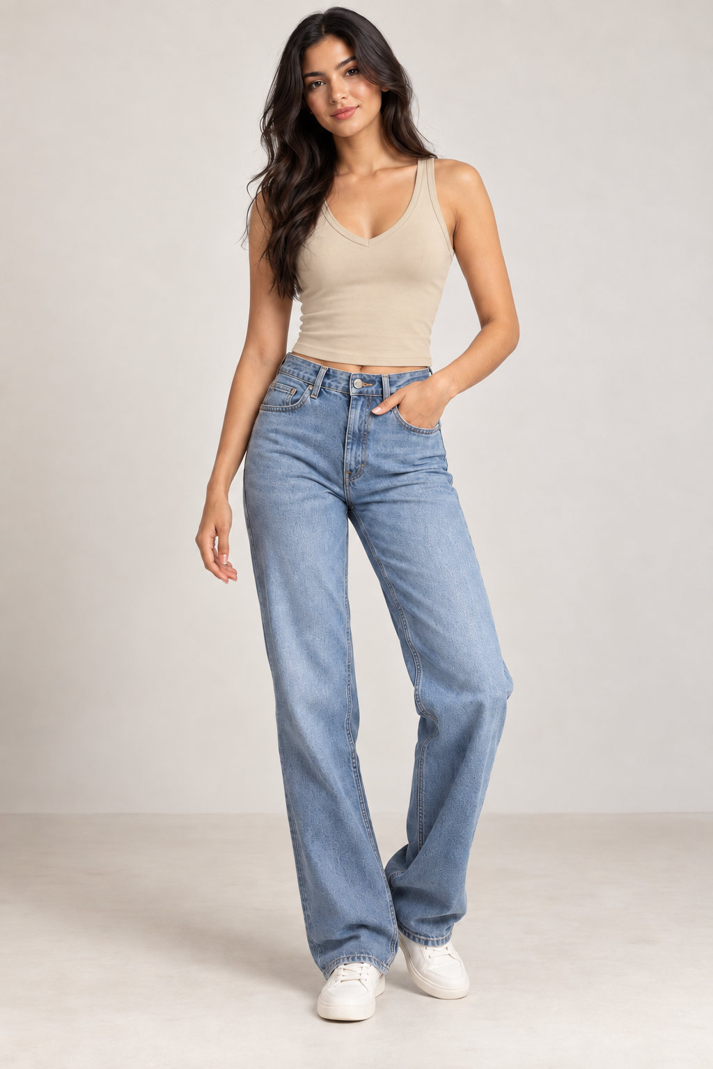 Model wearing a fitted beige V-neck crop tank top with blue high-waisted jeans and white sneakers.